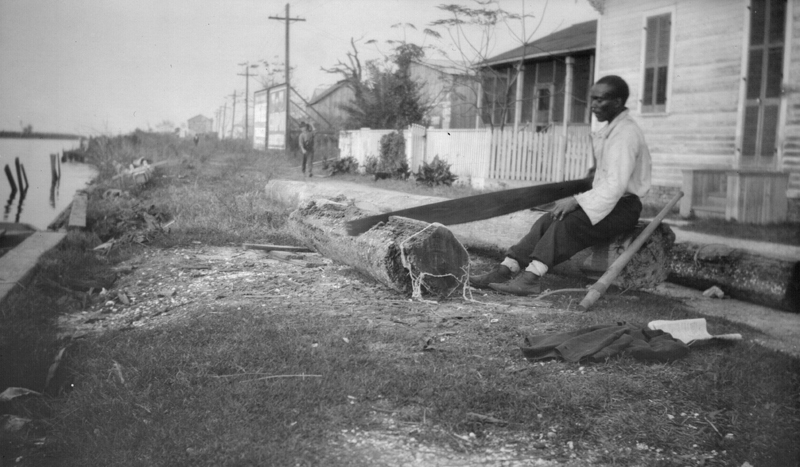 1919t_new_orleans_man_sawing_log_c1919